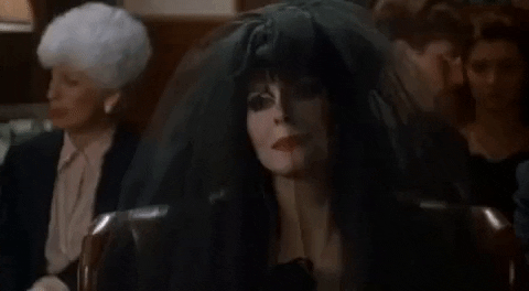 A personagem Elvira com um véu preto, em um funeral. Imagem ilustrativa para o conteúdo sobre falar sobre morte