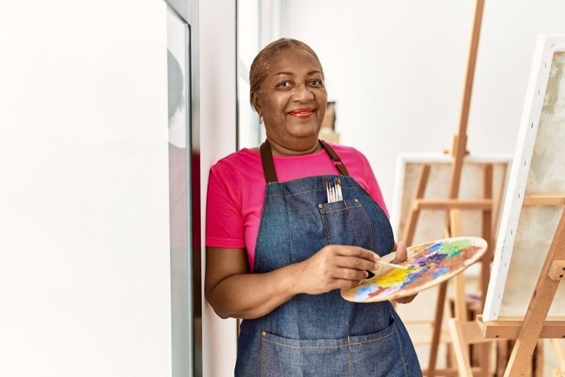 Uma mulher aprendendo a pintar, na busca de alcançar uma aposentadoria mais plena.