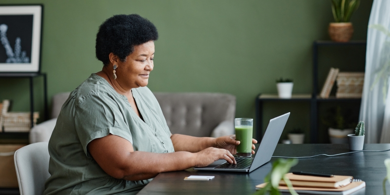 Uma senhora, em frente a um computador, estudando. Imagem para ilustrar a matéria sobre cursos sobre aposentadoria.