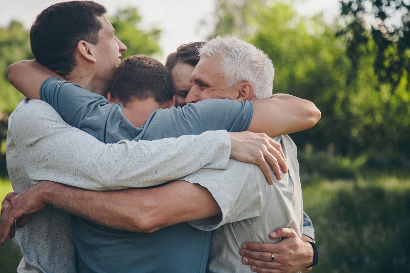 Como viver melhor: 15 hábitos para ter mais qualidade de vida no envelhecimento. Quatro homens se abraçam em círculo.