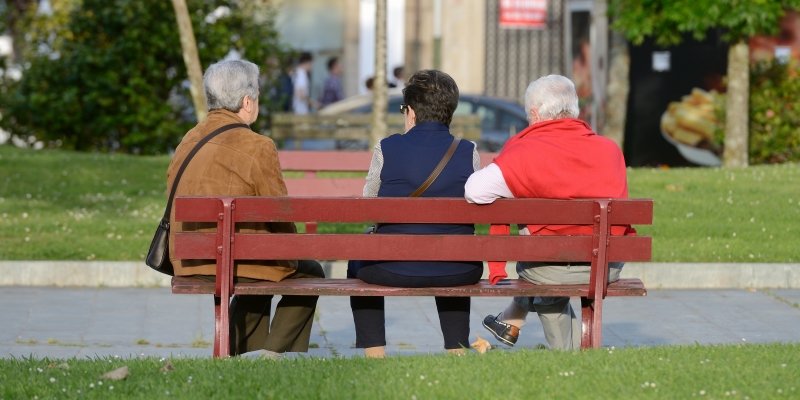 Três senhoras sentadas em um branco de praça. Imagem para ilustrar a matéria sobre expectativa de vida humana.