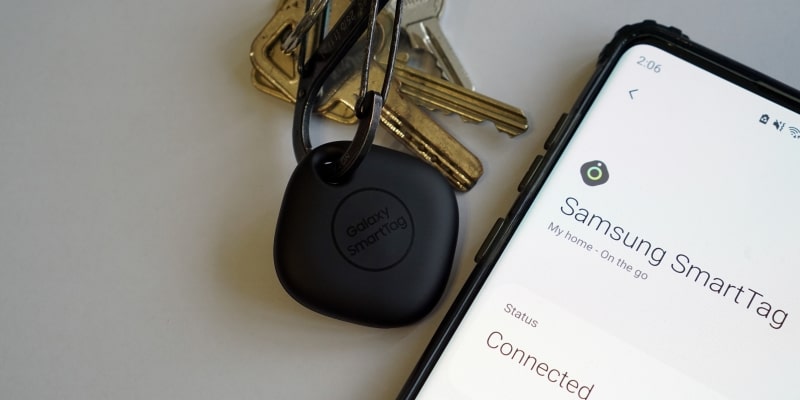 Uma smarttag da Samsung presa em um molho de chavez, ao lado de um celular mostrando que o aplicativo está conectado.