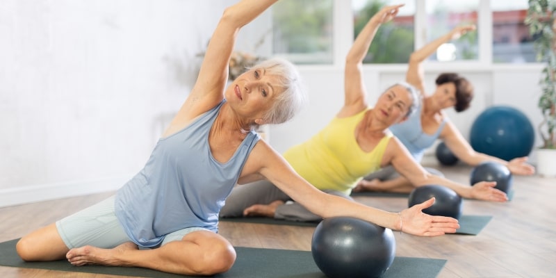 Três mulheres idosas praticando pilates. Imagem para ilustrar a matéria sobre mulheres vivem mais.