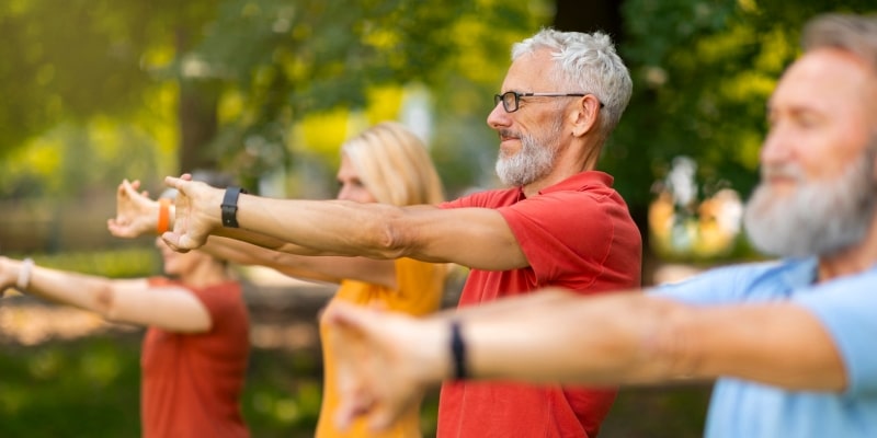 Um grupo de pessoas idosas praticando ioga, o exercício que melhora a atividade cerebral.