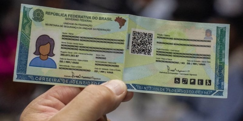 Uma mão segurando a nova carteira de identidade nacional.
