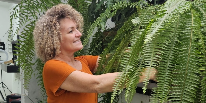 Uma mulher cuidados das plantas em casa - seu hobbie - e ativando a dopamina.