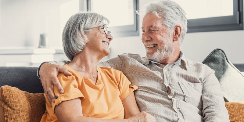 Um casal de idosos sorrindo, se olhando. Imagem para ilustrar a matéria sobre o Itaú Viver Mais.