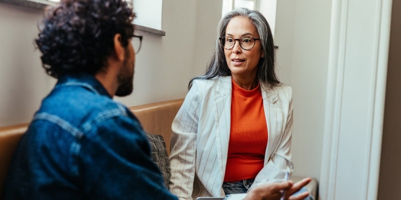 Uma mulher exercendo liderança forte ao conversar com seu colaborador.