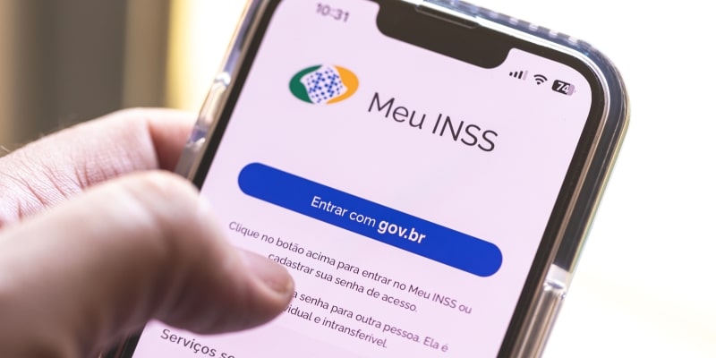 Um celular com o aplicativo do Meu INSS aberto. Imagem para ilustrar a matéria sobre o acordo de ressarcimento de descontos indevidos.
