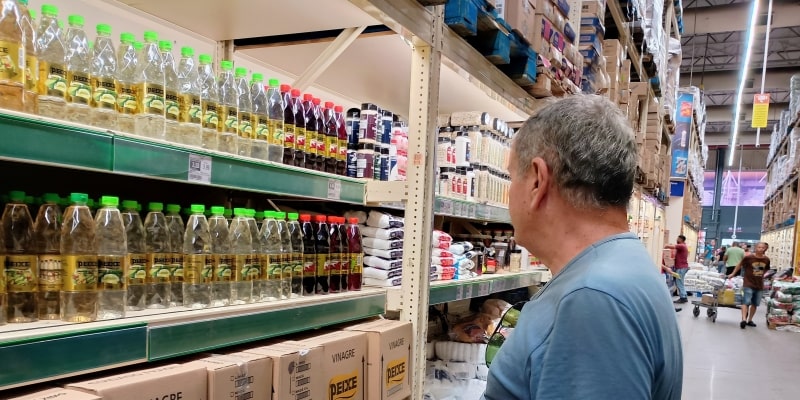 Um senhor olhando uma prateleira de supermercado no Brasil. Imagem para ilustrar a matéria sobre o tarifaço.