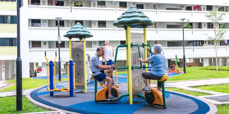 Idosos asiáticos fazendo atividade em um parque de um conjunto habitacional. Imagem para ilustrar a matéria sobre os centenários de Cingapura.