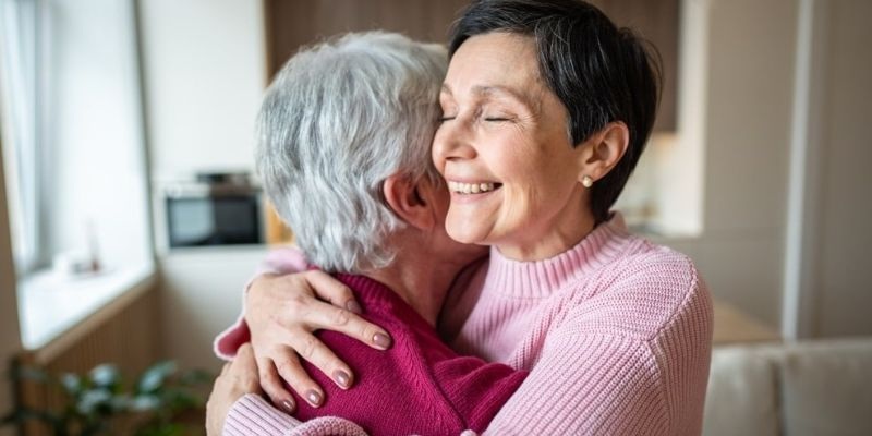 Duas mulheres demonstrando empatia uma com a outra, sendo uma mais velha e uma mais nova.