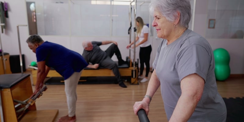 Um grupo de idosos praticando pilates para manter a mobilidade na terceira idade.
