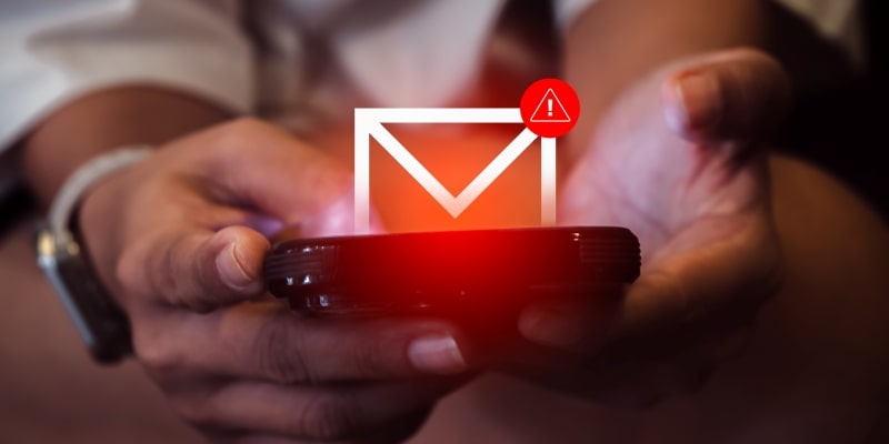 Uma pessoa segurando um celular que está recebendo uma mensagem suspeita de fraude. Imagem para ilustrar a matéria sobre o aumento das vítimas de golpes virtuais.