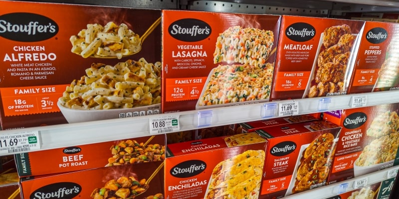 Uma prateleira de mercado com diversas lasanhas prontas. Imagem para ilustrar a matéria sobre alimentos ultraprocessados.
