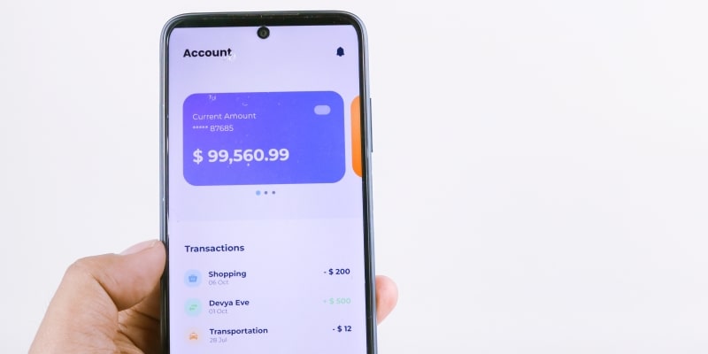 verificando saldo de conta bancária com aplicativo digital no celular. Imagem para ilustrar a matéria sobre instituições de pagamento.