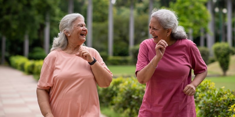 Duas mulheres idosas fazendo caminhada na rua, tentando se adaptar a melhor rotina para envelhecer bem.