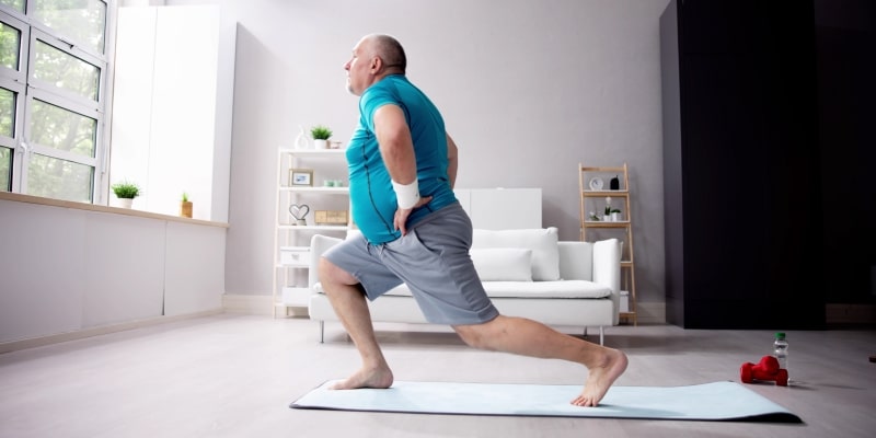 Um homem fazendo exercício em casa após descobrir que perder barriga é bom para o cérebro.