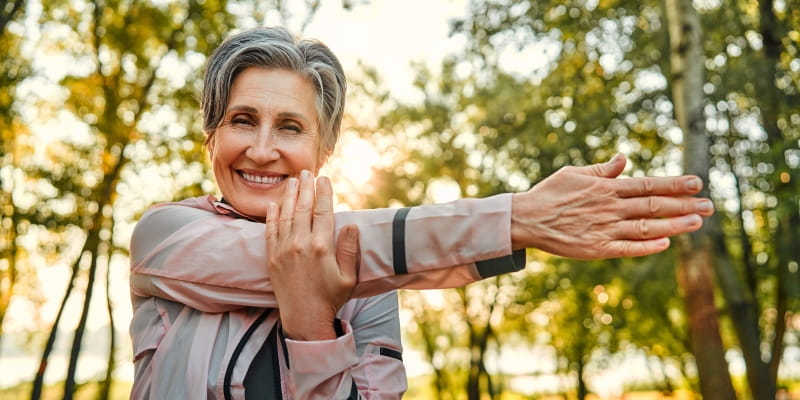Uma mulher sênior se alongando. Imagem para ilustrar a matéria sobre como viver mais.