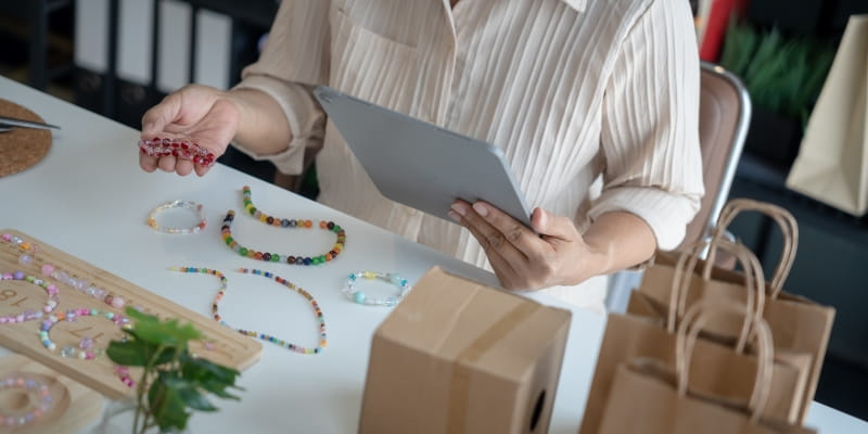 Foco na mesa de trabalho de artesanato de uma mulher que faz parte do grupo de empreendedores da Economia Prateada.