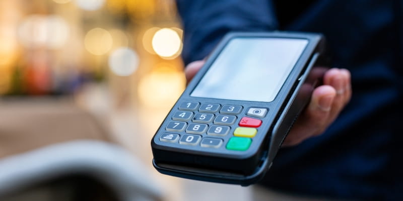 Um homem, aplicando o golpe do exame, entrando uma máquina com o visor sem nenhuma informação.