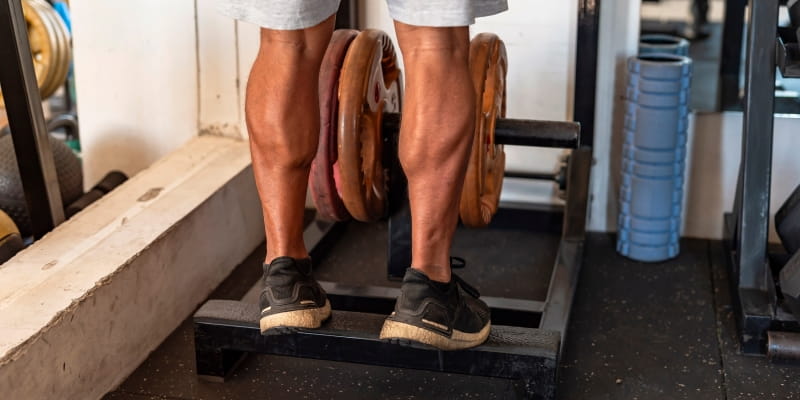 Como a panturrilha é o segundo coração, a imagem ilustra um homem fazendo exercícios para o músculo em uma academia.
