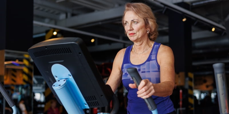 Uma mulher, fazendo exercício físico na academia, depois de perceber com mais ênfase os sinais de envelhecimento precoce.