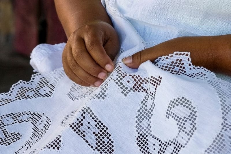 Mulher usando habilidade artesanal para fazer renda extra depois dos 50