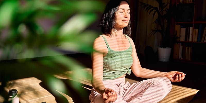 Um mulher fazendo meditação, ilustrando a matéria sobre Espiritualidade, Meditação e Yoga.