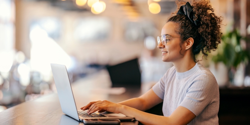 Um jovem freelancer trabalhando com seu computador em um espaço de coworking.